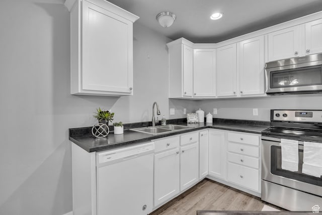 282 W 605 N Unit 307, Centerville, UT 84014 - kitchen featuring a sink, dark countertops, stainless steel appliances, white cabinetry, and light wood-style floors