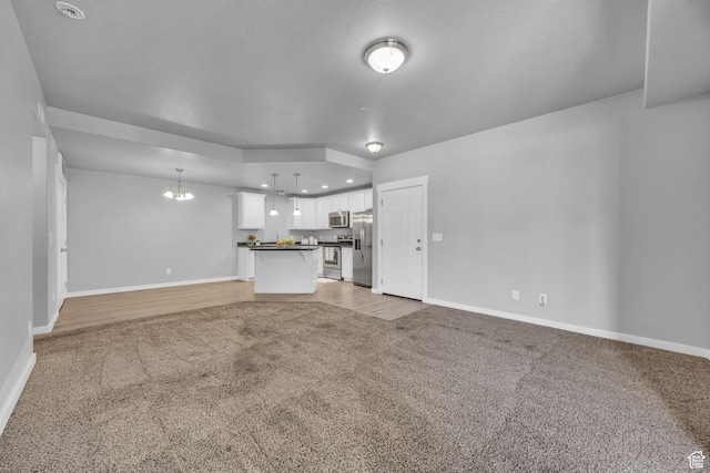 282 W 605 N Unit 307, Centerville, UT 84014 - unfurnished living room featuring a chandelier, light carpet, and baseboards