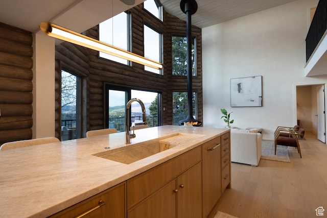 7370 N Buckboard Dr, Park City, UT 84098 - kitchen with a sink, high vaulted ceiling, light wood-style flooring, light countertops, and rustic walls