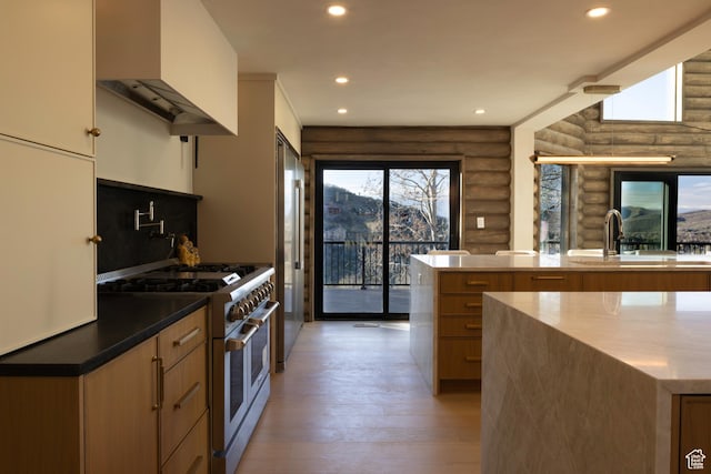 7370 N Buckboard Dr, Park City, UT 84098 - kitchen featuring a sink, wall chimney exhaust hood, log walls, high quality appliances, and light wood-style floors