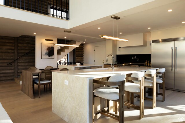 7370 N Buckboard Dr, Park City, UT 84098 - kitchen featuring a large island with sink, light wood-type flooring, recessed lighting, a kitchen bar, and stainless steel built in fridge