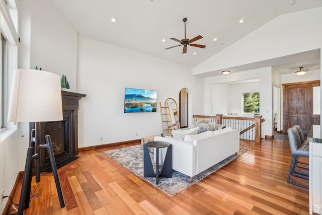 12221 Ross Creek Dr Unit 137, Kamas, UT 84036 - living room featuring arched walkways, light wood-style flooring, ceiling fan, and a glass covered fireplace