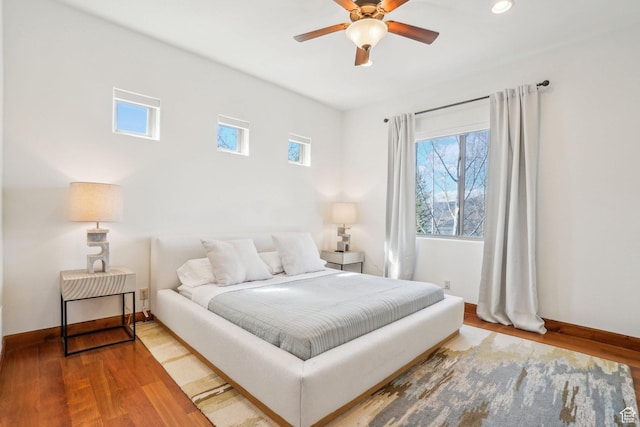 12221 Ross Creek Dr Unit 137, Kamas, UT 84036 - bedroom featuring multiple windows, a ceiling fan, wood finished floors, and baseboards