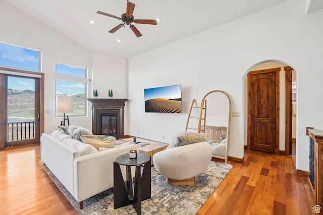 12221 Ross Creek Dr Unit 137, Kamas, UT 84036 - living area featuring high vaulted ceiling, ceiling fan, a glass covered fireplace, arched walkways, and light wood-style floors