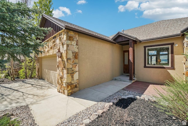 12221 Ross Creek Dr Unit 137, Kamas, UT 84036 - property entrance with an attached garage, stone siding, stucco siding, a shingled roof, and board and batten siding
