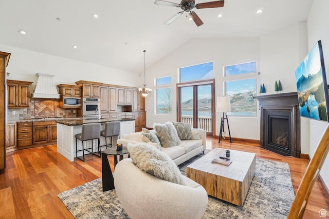 12221 Ross Creek Dr Unit 137, Kamas, UT 84036 - living area featuring recessed lighting, light wood finished floors, ceiling fan with notable chandelier, high vaulted ceiling, and a fireplace