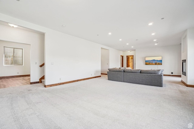 12221 Ross Creek Dr Unit 137, Kamas, UT 84036 - living room featuring stairway, light colored carpet, baseboards, and recessed lighting