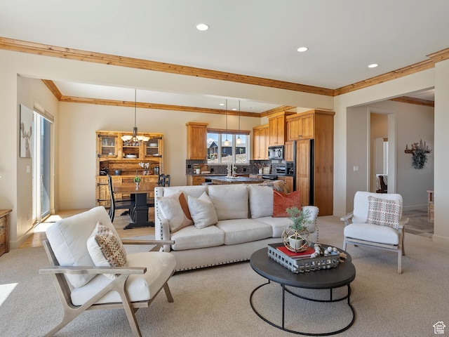 living room with light carpet, ornamental molding, a notable chandelier, and recessed lighting