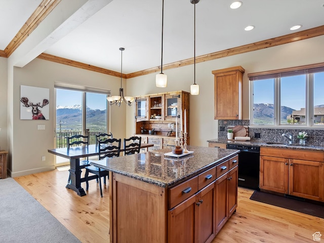 kitchen featuring a mountain view, dishwasher, a wealth of natural light, ornamental molding, and a sink