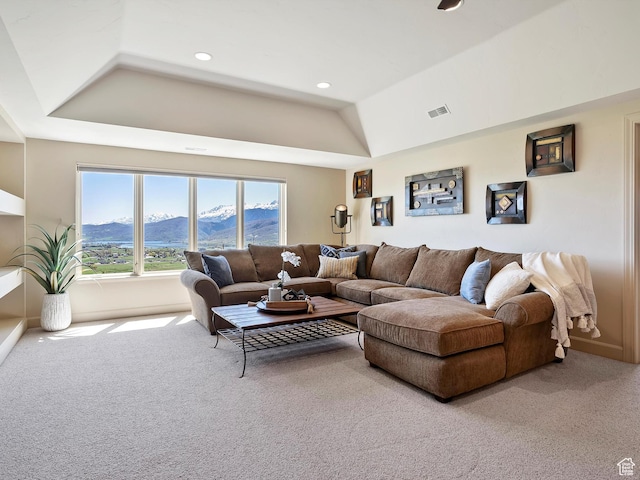 living room featuring carpet flooring, a mountain view, and a raised ceiling