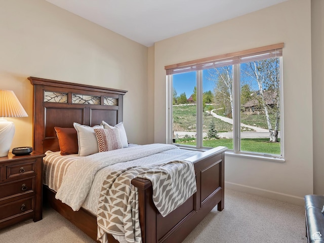 bedroom featuring light colored carpet and baseboards