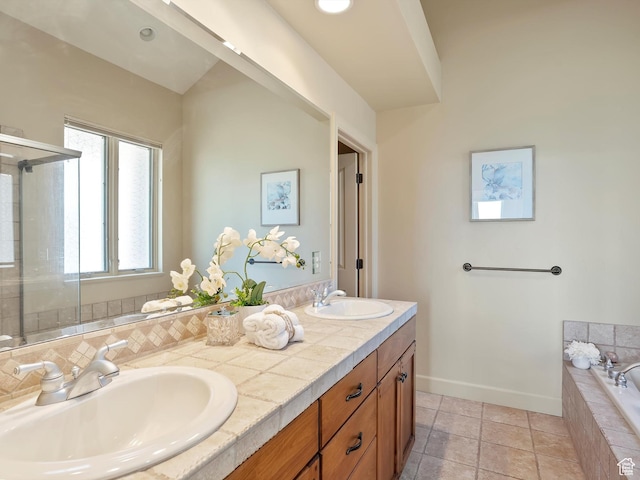 full bath featuring a sink, double vanity, baseboards, and a bath