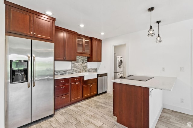 2025 Canyons Resort Dr Unit D4, Park City, UT 84098 - kitchen with stainless steel appliances, stacked washer / drying machine, light wood-style flooring, a peninsula, and tasteful backsplash