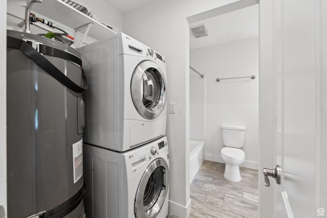 2025 Canyons Resort Dr Unit D4, Park City, UT 84098 - laundry area featuring stacked washer and clothes dryer, water heater, and light wood finished floors