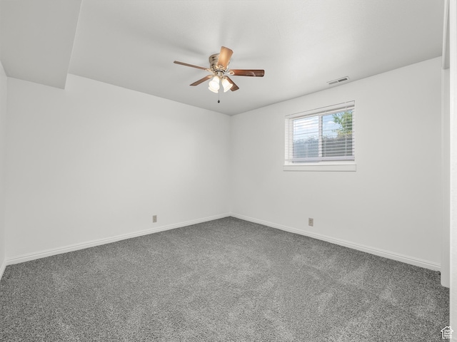empty room with baseboards, carpet floors, a ceiling fan, and visible vents