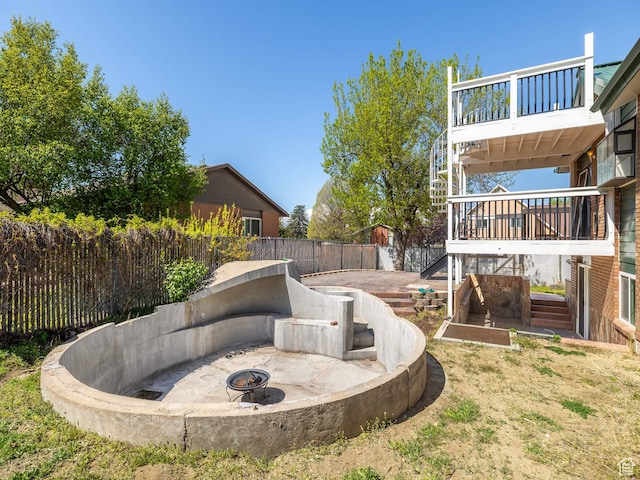 view of yard with stairs, a fire pit, a deck, and a fenced backyard