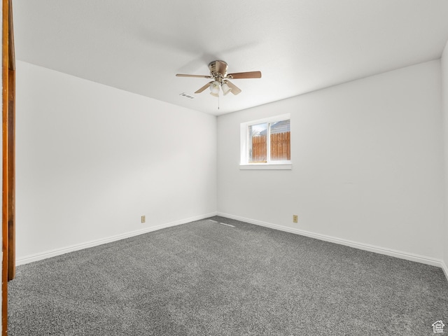 empty room with a ceiling fan, baseboards, dark colored carpet, and visible vents