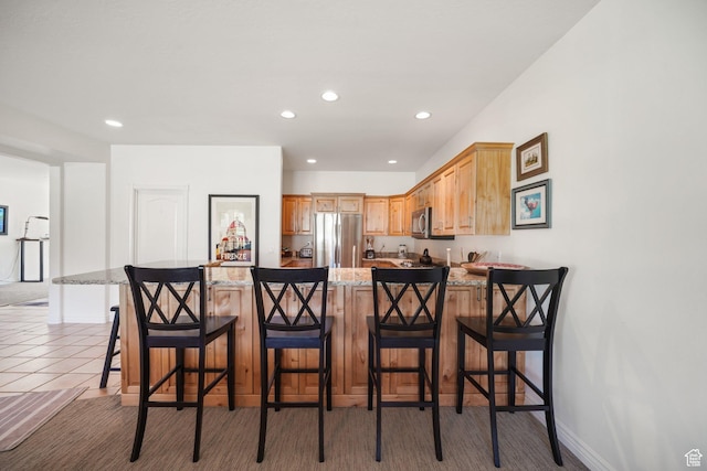 384 N Cottage Creek Ct W, Midway, UT 84049 - kitchen featuring recessed lighting, light stone counters, a peninsula, a kitchen breakfast bar, and stainless steel appliances