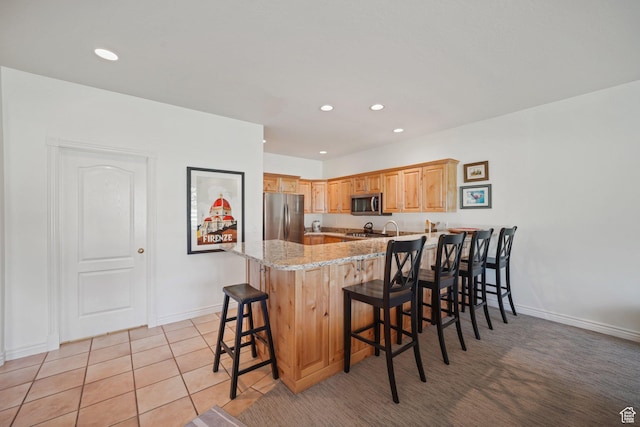 384 N Cottage Creek Ct W, Midway, UT 84049 - kitchen featuring a peninsula, stainless steel appliances, a kitchen breakfast bar, recessed lighting, and light stone countertops