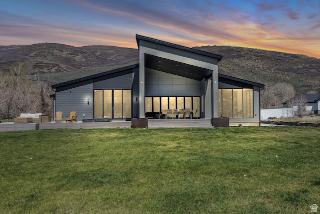 846 E 270 S, Kamas, UT 84036 - back of house at dusk with a mountain view, a lawn, a sunroom, and a patio