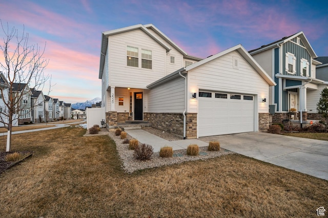 view of front of home with an attached garage, stone siding, a residential view, driveway, and a front lawn