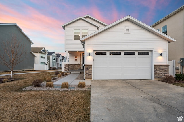 view of front of house featuring a garage, stone siding, and driveway