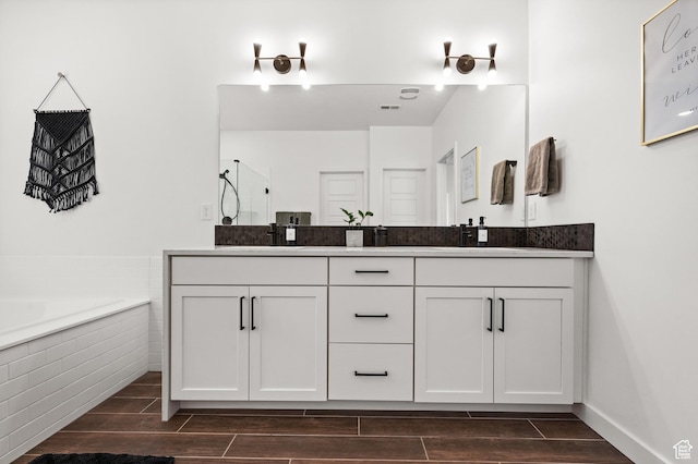 full bathroom with a sink, double vanity, wood tiled floor, and a bath