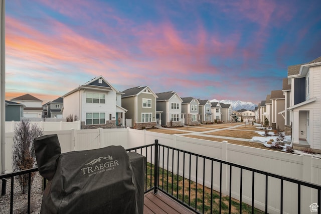 balcony at dusk featuring a residential view
