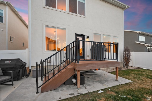 rear view of house featuring a patio, stucco siding, and fence