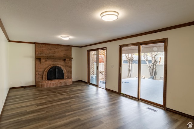 unfurnished living room with a textured ceiling, visible vents, crown molding, dark wood-style floors, and baseboards