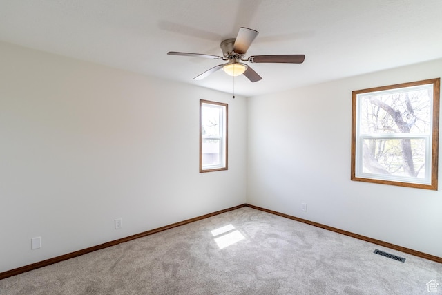 unfurnished room featuring baseboards, ceiling fan, visible vents, and carpet