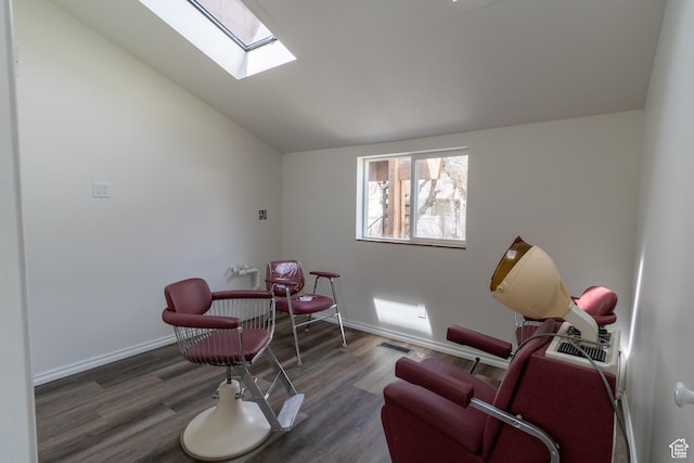 living area featuring lofted ceiling with skylight, baseboards, visible vents, and wood finished floors