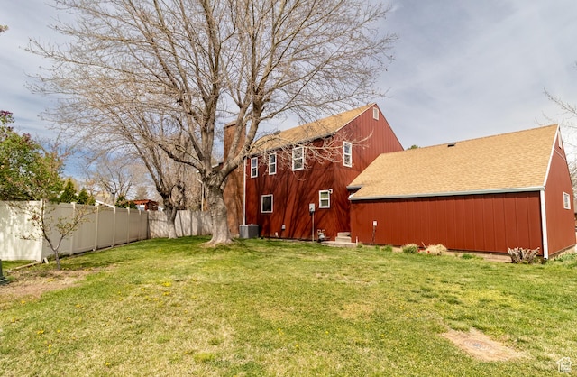 view of yard featuring central air condition unit and fence