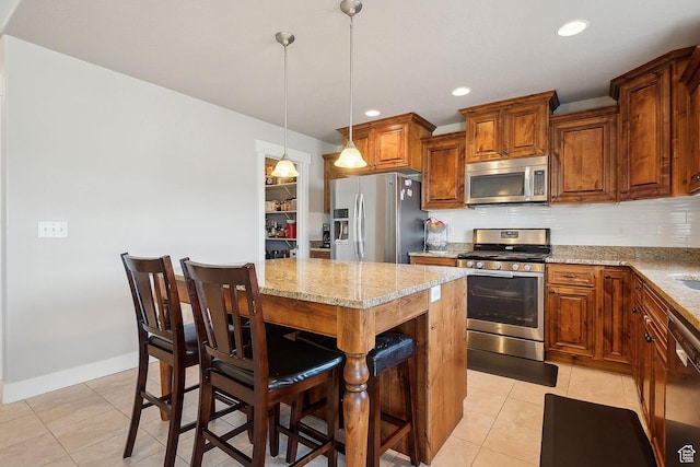 667 S Falkirk Rd Unit 24, Heber City, UT 84032 - kitchen featuring light tile patterned floors, a breakfast bar, stainless steel appliances, light stone countertops, and a kitchen island