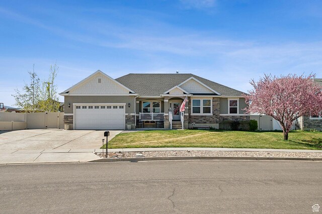 667 S Falkirk Rd Unit 24, Heber City, UT 84032 - view of front of property with a porch, fence, an attached garage, stone siding, and a front lawn