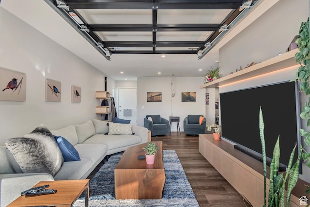 living room featuring dark wood-style flooring, a garage, and recessed lighting