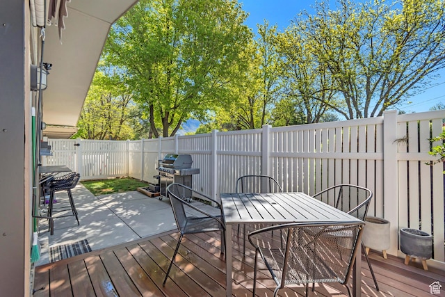 wooden deck featuring a fenced backyard, area for grilling, and outdoor dining area
