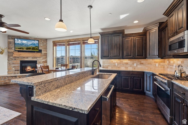 9855 N N Vista Dr Unit 104, Heber City, UT 84032 - kitchen featuring a sink, ceiling fan, light stone counters, and appliances with stainless steel finishes