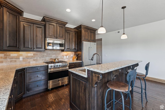 9855 N N Vista Dr Unit 104, Heber City, UT 84032 - kitchen featuring dark brown cabinets, a sink, high end appliances, decorative backsplash, and dark wood-type flooring
