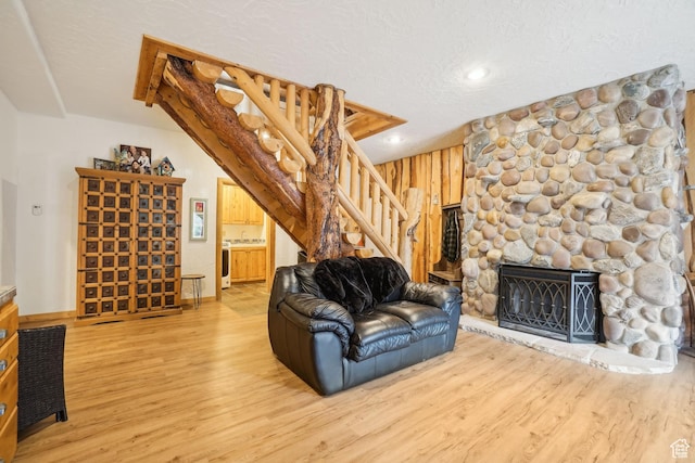 living area with wood finished floors, a fireplace, stairway, wooden walls, and recessed lighting