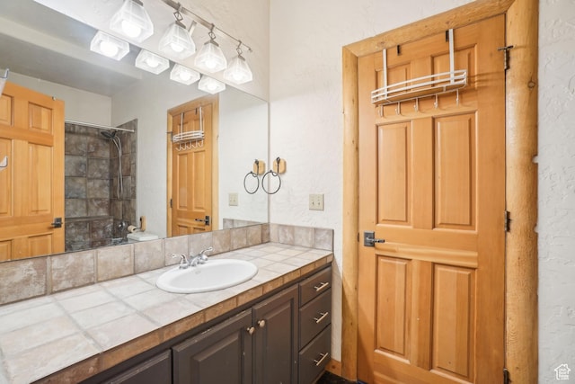 full bath featuring vanity, shower / bath combination, and a textured wall
