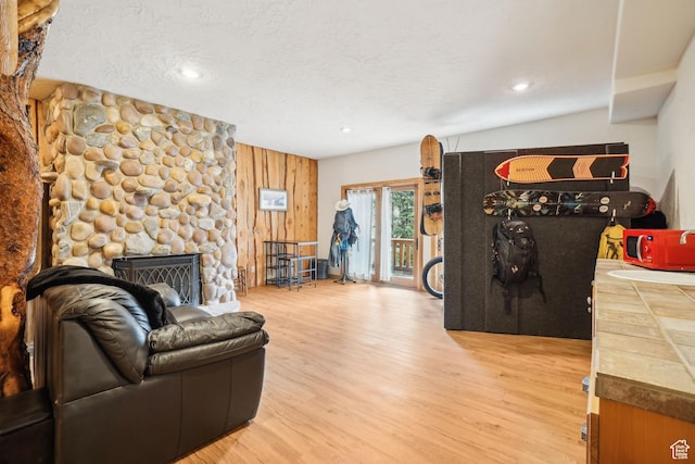living room with wooden walls, a fireplace, recessed lighting, and wood finished floors