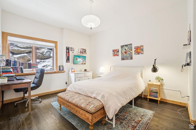 bedroom featuring baseboards and wood finished floors