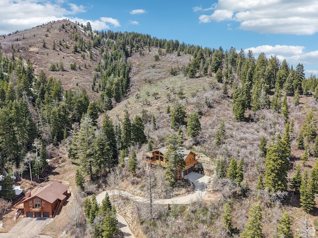 birds eye view of property featuring a wooded view and a mountain view
