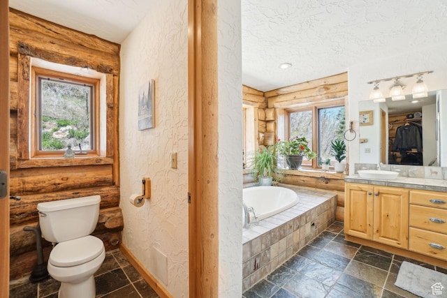 full bath with toilet, stone tile flooring, a bath, log walls, and a textured wall