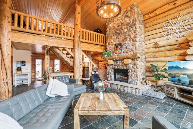 living area with a towering ceiling, log walls, stairway, a fireplace, and wood ceiling
