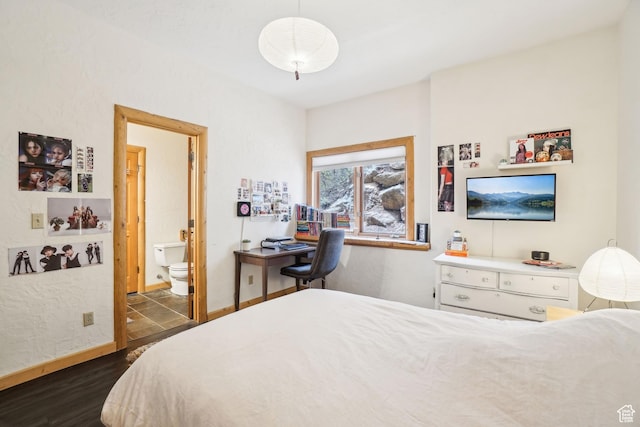 bedroom with connected bathroom, baseboards, and dark wood-type flooring