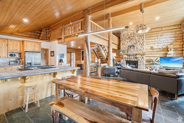 dining space with a fireplace, stone tile flooring, wooden ceiling, rustic walls, and recessed lighting