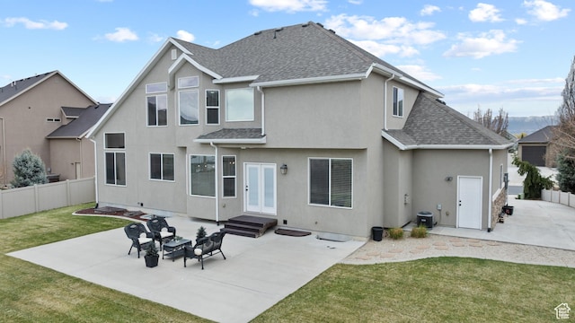 rear view of property with a patio area, fence, a yard, stucco siding, and a shingled roof
