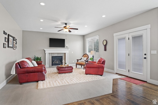 living area with recessed lighting, baseboards, ceiling fan, wood finished floors, and a tile fireplace